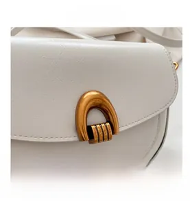 Detail of off-white lychee pattern leather shoulder bag with vintage bronze U-shaped lock