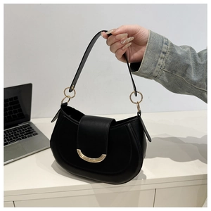 Detail of a black leather half-moon bag with elegant curved gold metal buckle and ring