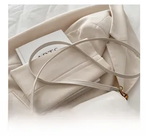 Close-up of cream textured leather handbag with a vintage gold circular metal lock