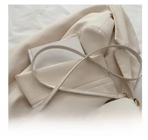 Détail de la bandoulière réglable et boucle dorée sur sac baguette rétro beige