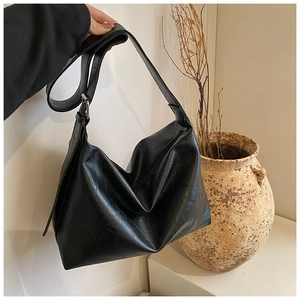 Detailed view of black retro faux leather hobo bag with wide adjustable shoulder strap
