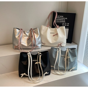 Detail of four colorful tote bags with heart rivets and bowknot ballet style accents