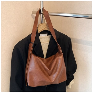 Macro view of vintage brown tote bag with adjustable strap on professional model mannequin