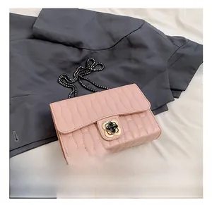 Detailed shot of pink quilted leather bag featuring a gold floral lock and chain strap