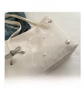 Détails de la surface plissée du sac blanc avec perles et nœud en métal orné