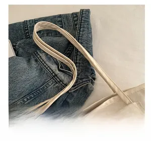 Vue détaillée d'un sac cabas blanc crème avec de fines anses et une texture souple