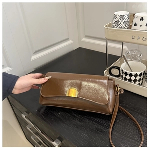 Detail of vintage brown oil wax leather shoulder bag with golden rectangular metal buckle