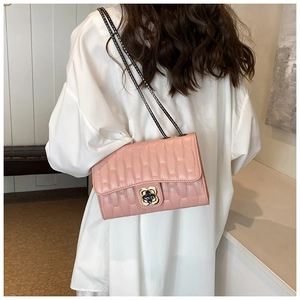 Détail du sac à bandoulière matelassé rose avec fermoir floral et chaîne noire