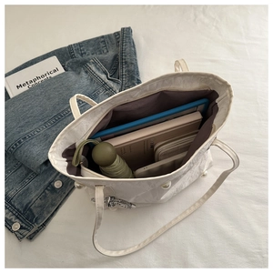 Interior detail of white pleated tote bag showing large capacity for tablet and daily items