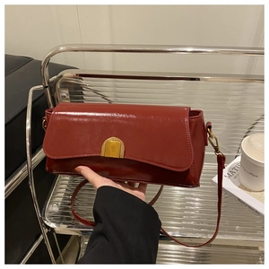 Detail showing high-gloss burgundy leather texture and golden U-shaped buckle closure