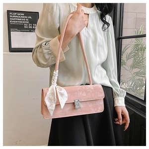 Pink suede-textured crossbody bag with square rhinestone buckle and decorative silk ribbon
