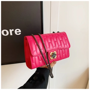 Détail du sac matelassé fuchsia avec fermoir fleur dorée et bandoulière chaîne
