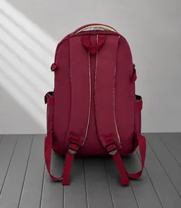 Detailansicht eines weinroten Rucksacks mit gepolsterten Trägern und robustem Stoff
