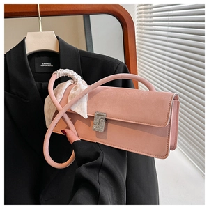Détail du sac bandoulière en cuir rose avec boucle en cristal en S et décor de foulard en soie