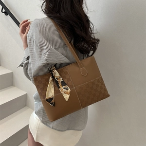 Brown tote bag with checkerboard pattern and silk scarf on white stairs model view