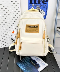 Detailansicht eines cremeweißen Rucksacks mit hoher Kapazität, Taschen und Entenanhänger