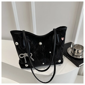Detail of black tote bag with decorative pearls, rhinestone bow and heart crystal