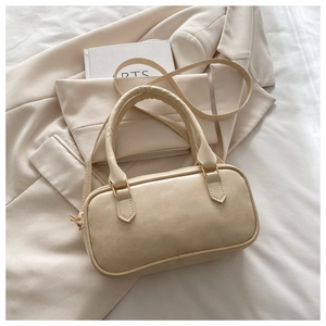 Detail of off-white faux leather Boston bag with golden hardware and handles