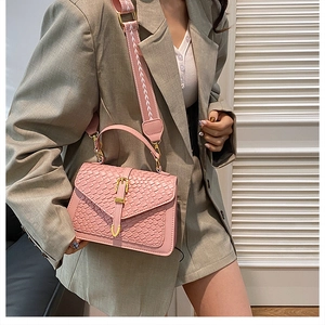 Pink woven texture shoulder bag with golden buckle and floral jacquard strap on model