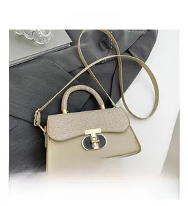 Detail of beige crossbody bag featuring woven texture flap and golden oval metal lock
