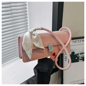 Detail of pink shoulder bag featuring decorative silk scarf wrap and sparkling diamond buckle