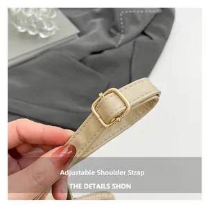Detail of adjustable beige PU leather shoulder strap with golden buckle and stitching