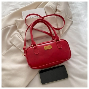 Detail of red vintage bowling bag with matte PU leather texture and gold metal plaque