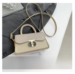 Detail of beige texture bag with gold T-clasp and woven handle shown with phone