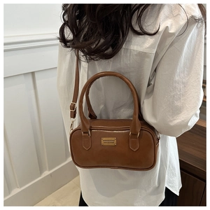Close-up of retro brown PU leather bowling bag featuring a gold metal decorative plate
