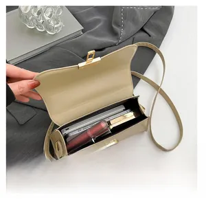 Detail view of the beige crossbody box bag interior showing capacity for makeup and phone