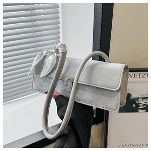 Detail of silver crossbody bag with diamond buckle and elegant printed silk scarf handle