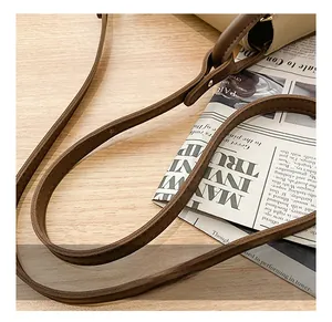 Detail of adjustable brown leather shoulder strap with stitching on a chic square bag