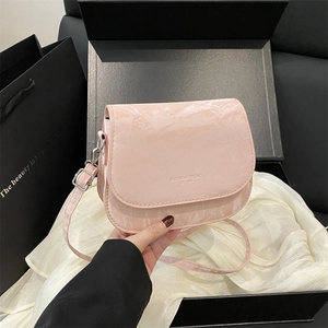 Détail d'un sac besace rose brillant en similicuir avec lettrage tendance à la mode