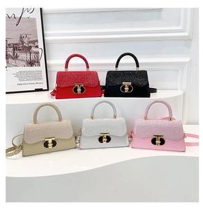Detail view of five stylish crossbody bags featuring glitter fabric and metal T-locks