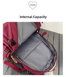 Vista detallada del interior de la mochila granate con compartimento principal y divisor