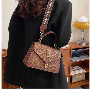 Brown leather crossbody bag with woven texture and vintage jacquard strap detail