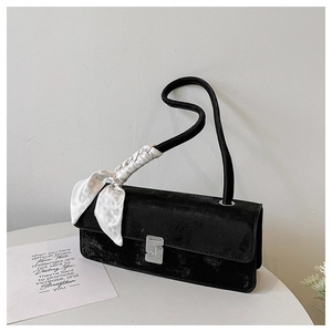 Detail of black velvet shoulder bag with silver rhinestone buckle and silk scarf handle