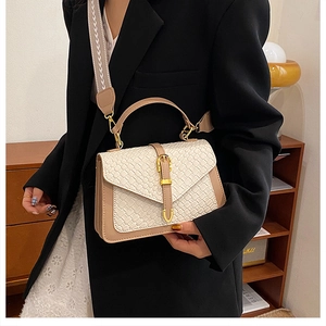Close-up of woven texture detail and gold buckle on a retro beige crossbody bag