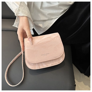 Gros plan détaillé du sac besace rose avec texture marbrée et logo embossé tendance