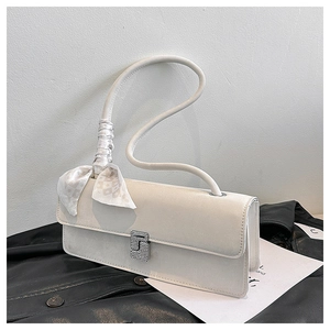 Detail of ivory baguette bag with silver rhinestone buckle and patterned silk scarf