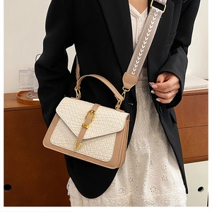 Close-up of stylish handbag featuring woven texture flap and khaki leather finish