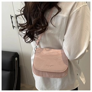 Détail du sac selle rose avec lettrage FASHION TREND et finition en cuir texturé