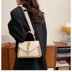 Detail of woven small square bag with ethnic print strap and golden buckle hardware