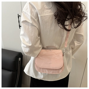 Détail du sac bandoulière en cuir rose à texture marbrée avec gravure Fashion Trend