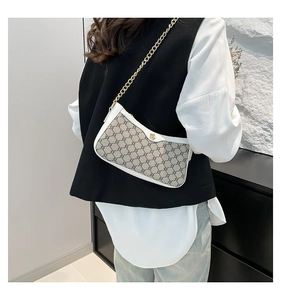Detail of grey monogram underarm bag with gold rose clasp and metallic chain strap