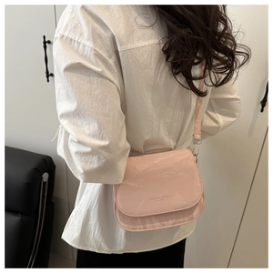 Vue détaillée du sac besace rose avec texture marbrée et slogan tendance à l'épaule