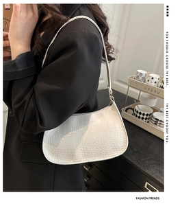 Minimalist white faux crocodile texture underarm bag styled with a black blazer
