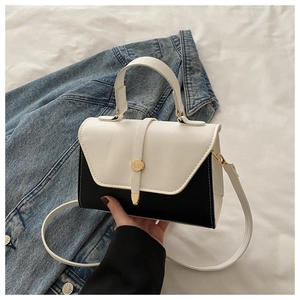 Détail d'un mini sac carré bicolore noir et blanc avec fermoir circulaire doré chic