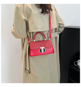Detail of red crossbody bag with sequined flap and gold T-logo metal rotary clasp