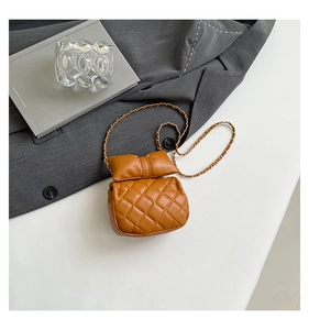 Detail of a brown quilted leather chain bag with an elegant bow accent and metal strap